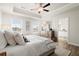 Relaxing main bedroom featuring a tray ceiling, a ceiling fan, and an en-suite bathroom entrance at 847 Pensive Run, Dacula, GA 30019