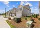 Exterior facade of townhomes with front lawns and utility boxes on a sunny day at 847 Pensive Run, Dacula, GA 30019
