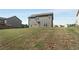 Backyard view with a grassy hill, gray siding, and manicured lawn at 336 Elaina Cir, Locust Grove, GA 30248