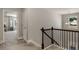 Upstairs hallway with carpet, wooden banister, natural light, and an open doorway to a bedroom at 336 Elaina Cir, Locust Grove, GA 30248