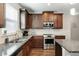 Well-equipped kitchen featuring stainless steel appliances, granite countertops, and dark wood cabinetry with ample storage at 336 Elaina Cir, Locust Grove, GA 30248