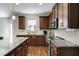 A well-lit kitchen with stainless steel appliances, dark wood cabinets, and granite countertops, offering modern amenities at 336 Elaina Cir, Locust Grove, GA 30248