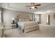 Large main bedroom with neutral color palette, tray ceiling, plush carpeting, and elegant decor at 336 Elaina Cir, Locust Grove, GA 30248