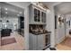 Elegant bar area with gray cabinetry, glass-front display, beverage fridge, and stylish lighting at 703 Cumberland Ne Cir, Atlanta, GA 30306