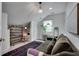 Cozy bonus room featuring a comfortable sofa, large rug, and storage shelves at 703 Cumberland Ne Cir, Atlanta, GA 30306