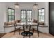 Cozy dining area with built-in seating, chandelier lighting, and garden views through black-framed windows at 703 Cumberland Ne Cir, Atlanta, GA 30306