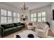 Bright living room featuring a vintage chandelier, modern seating, and hardwood floors at 703 Cumberland Ne Cir, Atlanta, GA 30306