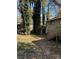 View of the backyard with tall mature trees, a green lawn, and a shed at 865 Cherrydale Ln, Woodstock, GA 30189
