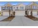 Charming townhome exterior features a two-car garage, brick facade, and well-manicured landscaping at 936 Elwood St, Dacula, GA 30019
