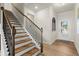 Elegant staircase with wood treads and black iron railings leading to the upper level of the home at 936 Elwood St, Dacula, GA 30019