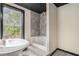 Bathroom featuring a step-in shower with tiled walls, a large window, and a modern sink at 206 Towler Dr, Loganville, GA 30052
