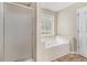 Bathroom featuring a shower, garden tub, and a window for natural light at 206 Towler Dr, Loganville, GA 30052