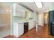 Galley kitchen boasting white cabinetry, hardwood floors, and modern appliances at 206 Towler Dr, Loganville, GA 30052