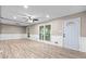 Spacious living room with wood floors, modern ceiling fan, recessed lights, and access to the outside through sliding glass doors at 2617 Peggy Sue Ln, Morrow, GA 30260