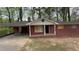 Charming brick home featuring a carport and a well-maintained yard; windows are boarded at 6344 Fitzgerald Ln, Austell, GA 30168
