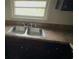 Kitchen area featuring a double stainless sink, Formica countertops, and basic cabinetry at 6344 Fitzgerald Ln, Austell, GA 30168