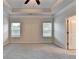 Large carpeted bedroom with windows offering natural light and an open doorway at 1431 Winding Ridge Trl, Buford, GA 30548