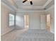 Carpeted bedroom with ceiling fan, trim, and multiple windows for natural light at 1431 Winding Ridge Trl, Buford, GA 30548