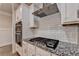 Close up on a modern kitchen featuring granite countertops, white cabinetry, and stainless steel appliances at 1431 Winding Ridge Trl, Buford, GA 30548