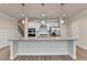 Open kitchen with a large island featuring granite countertops and modern pendant lighting at 1431 Winding Ridge Trl, Buford, GA 30548
