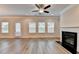 Cozy living room with a fireplace, hardwood flooring, and natural light from three windows at 1431 Winding Ridge Trl, Buford, GA 30548