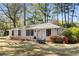 Charming white brick home with manicured lawn and blue Adirondack chairs on the front lawn at 200 Heaton Park Dr, Decatur, GA 30030