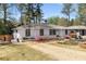 Charming white brick home with manicured lawn, colorful flowerbeds, and a gravel driveway at 200 Heaton Park Dr, Decatur, GA 30030