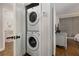 Efficient laundry closet with stacked washer and dryer, plus a view of a nearby bedroom with TV at 200 Heaton Park Dr, Decatur, GA 30030