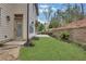This back yard has a small stone patio, green grass, and a retaining wall at 3360 Camellia Ln, Suwanee, GA 30024