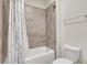 Tiled bathroom featuring a shower with a shower curtain and a white toilet at 3360 Camellia Ln, Suwanee, GA 30024