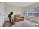 Spacious bonus room with a comfortable leather loveseat and large windows at 3360 Camellia Ln, Suwanee, GA 30024