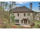 Exterior view of a light beige home with a chimney, complemented by green foliage and a patio area at 3360 Camellia Ln, Suwanee, GA 30024