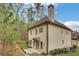 View of the home's exterior featuring a rear patio, well-maintained landscaping, and architectural details at 3360 Camellia Ln, Suwanee, GA 30024