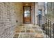 Elegant front entryway with stone steps, brick facade, and a stylish wooden door at 3360 Camellia Ln, Suwanee, GA 30024