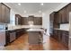 Kitchen featuring stainless steel appliances, dark cabinets, granite countertops, and an island with seating at 3360 Camellia Ln, Suwanee, GA 30024