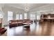 Open-concept living room with hardwood floors, comfortable seating, and a modern light fixture at 3360 Camellia Ln, Suwanee, GA 30024