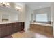 This main bathroom has double sinks, a shower, tile flooring, and a bathtub at 3360 Camellia Ln, Suwanee, GA 30024