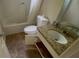 Bathroom with vinyl flooring, tub with shower, toilet and vanity with granite countertop at 100 Waters Edge Dr, Locust Grove, GA 30248