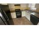 Traditional kitchen with black appliances, granite countertops, and tiled flooring at 100 Waters Edge Dr, Locust Grove, GA 30248