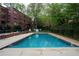Outdoor swimming pool nestled amongst lush greenery near a brick apartment building at 1380 Chalmette Ne Dr # 3, Atlanta, GA 30306