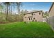 Expansive backyard featuring a well-maintained lawn, mature trees, and the home's rear facade at 3892 Trillium Wood Trl, Snellville, GA 30039