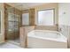 Bathroom featuring a soaking tub with tile surround and a glass-enclosed shower with tiled walls at 3892 Trillium Wood Trl, Snellville, GA 30039