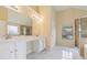 Bright bathroom featuring double sinks, granite countertops, and a glass-enclosed shower, illuminated by vanity lights at 3892 Trillium Wood Trl, Snellville, GA 30039
