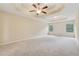 Main bedroom with tray ceiling, ceiling fan, and windows for natural light at 3892 Trillium Wood Trl, Snellville, GA 30039