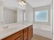 Bathroom featuring a double sink vanity, large mirror, soaking tub, and natural light at 57 Craig Meadows Ln, Douglasville, GA 30134