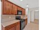 Kitchen with wooden cabinets, black appliances, and tile backsplash at 57 Craig Meadows Ln, Douglasville, GA 30134