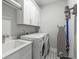 This modern laundry room features front loading machines, ample storage space and durable floor for easy cleaning at 111 Brighton Blvd, Woodstock, GA 30188