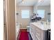 Bright bathroom featuring a white vanity, a large mirror, and a red accent rug at 169 Concorde Dr, Villa Rica, GA 30180