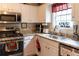 Well-lit kitchen with stainless steel appliances, light granite countertops and white cabinetry at 169 Concorde Dr, Villa Rica, GA 30180