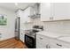 Modern kitchen featuring stainless steel appliances, white cabinetry, subway tile backsplash, and hardwood floors at 2146 Trailwood Rd, Decatur, GA 30032